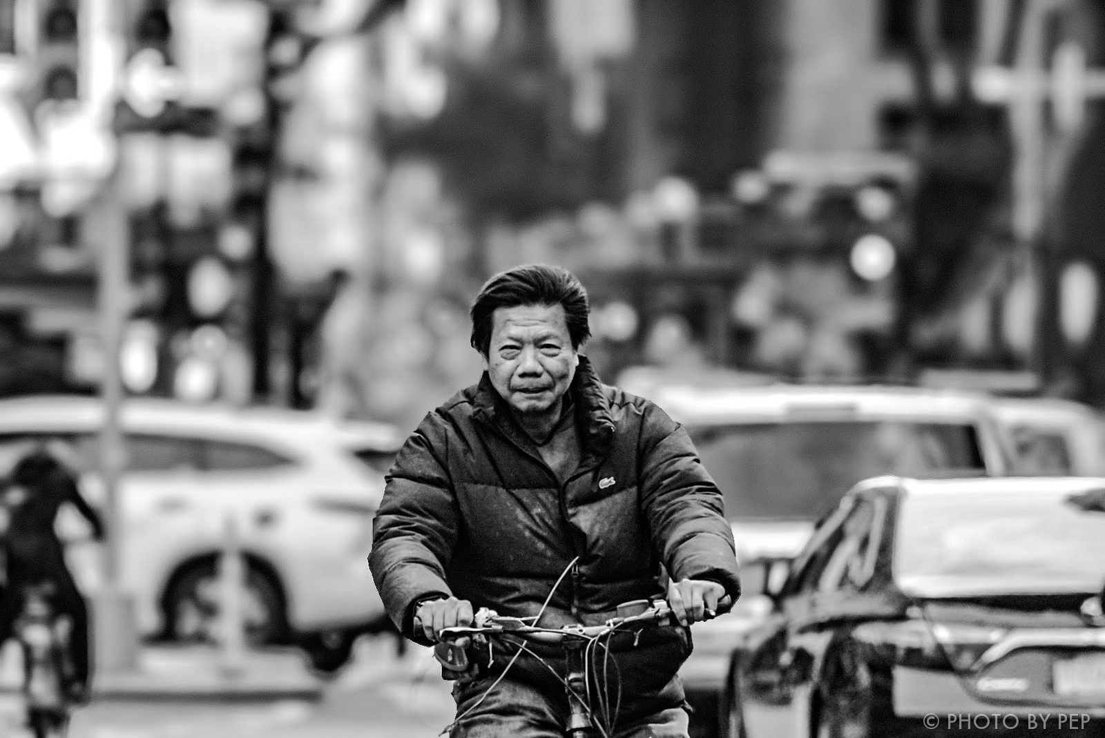 Black-and-white street cyclist riding toward the camera in New York