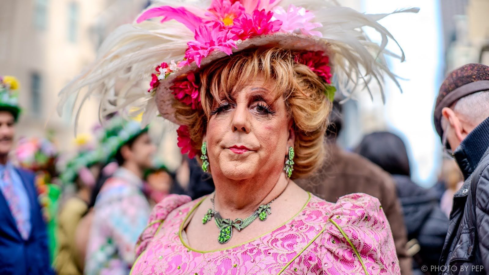 Street portrait with pink flower hat and green jewelry